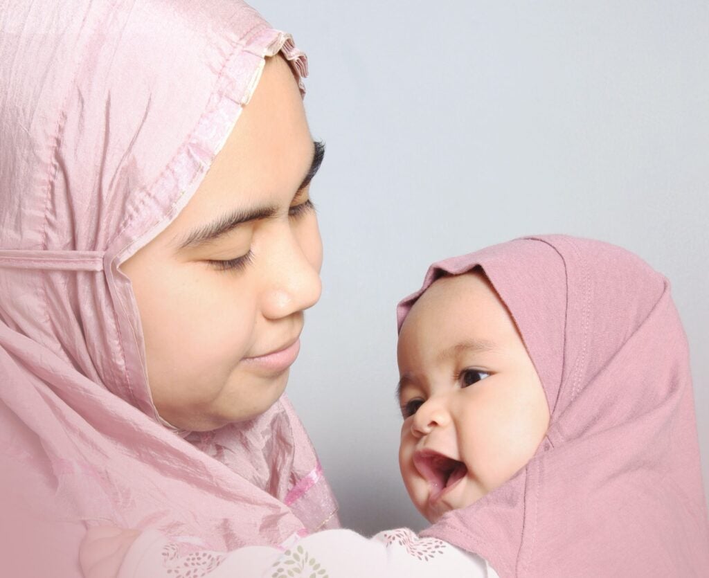 Mom And Baby In Head Scarves Playing